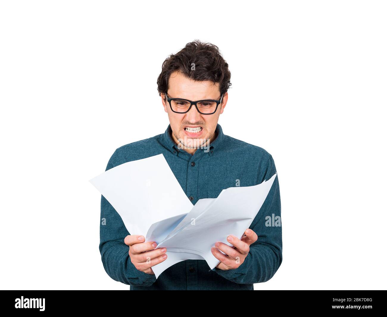 Hombre de negocios molesto mirando furioso los documentos de papel en sus manos aislados sobre fondo blanco. Trabajador de negocios irritado por la rutina a del lugar de trabajo Foto de stock