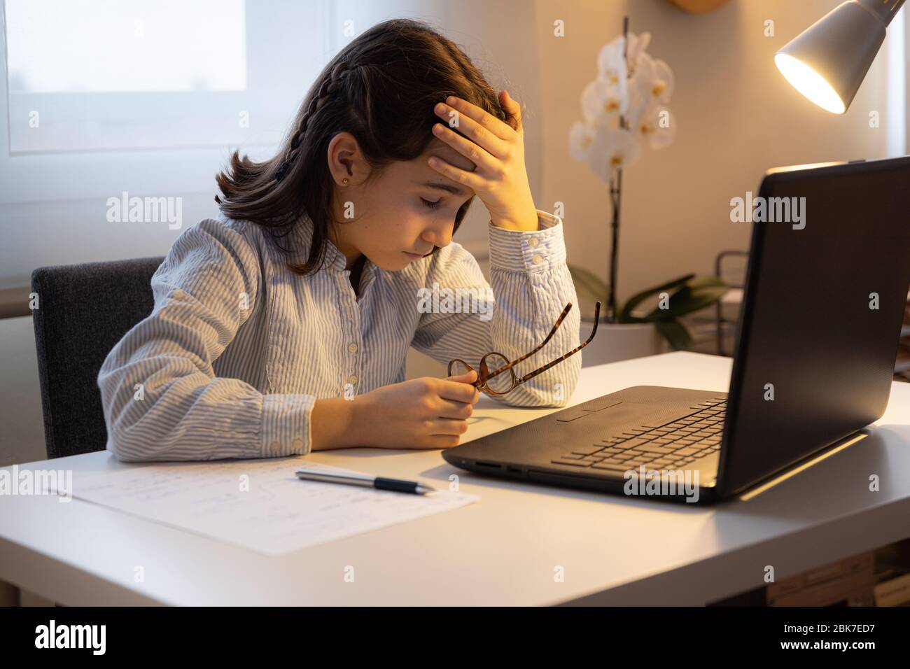 Chica agotada tratando de estudiar con la computadora Foto de stock