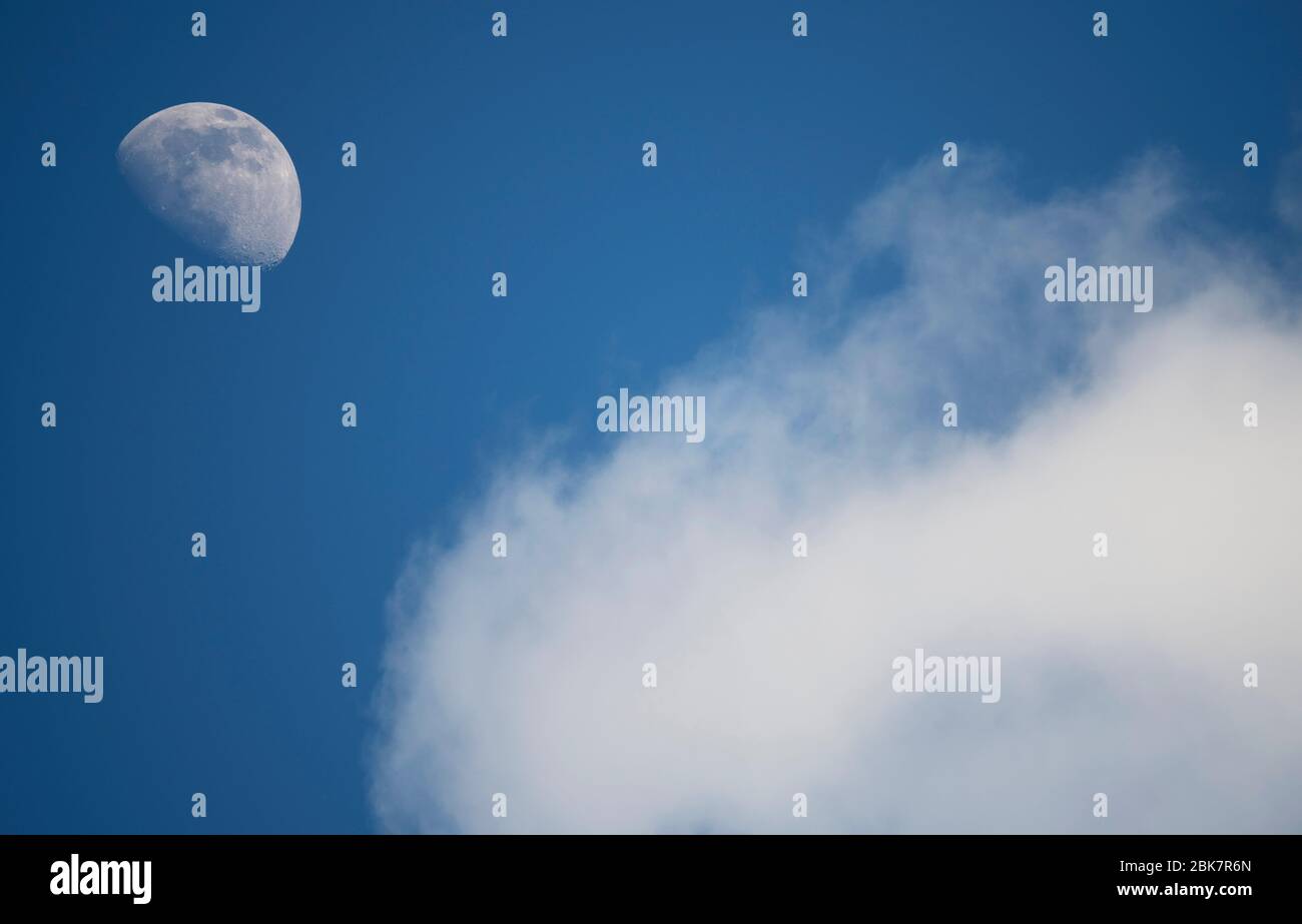 Londres, Reino Unido. 2 de mayo de 2020. Fase lunar contra un cielo azul de la tarde con nubes que pasan. Crédito: Malcolm Park/Alamy Live News. Foto de stock