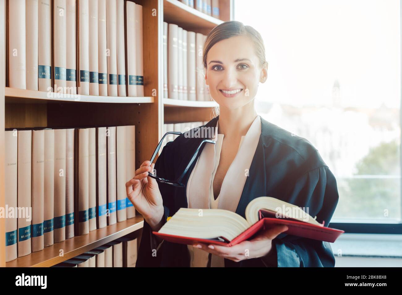 Abogado trabajando en un caso difícil de leer en la biblioteca Foto de stock