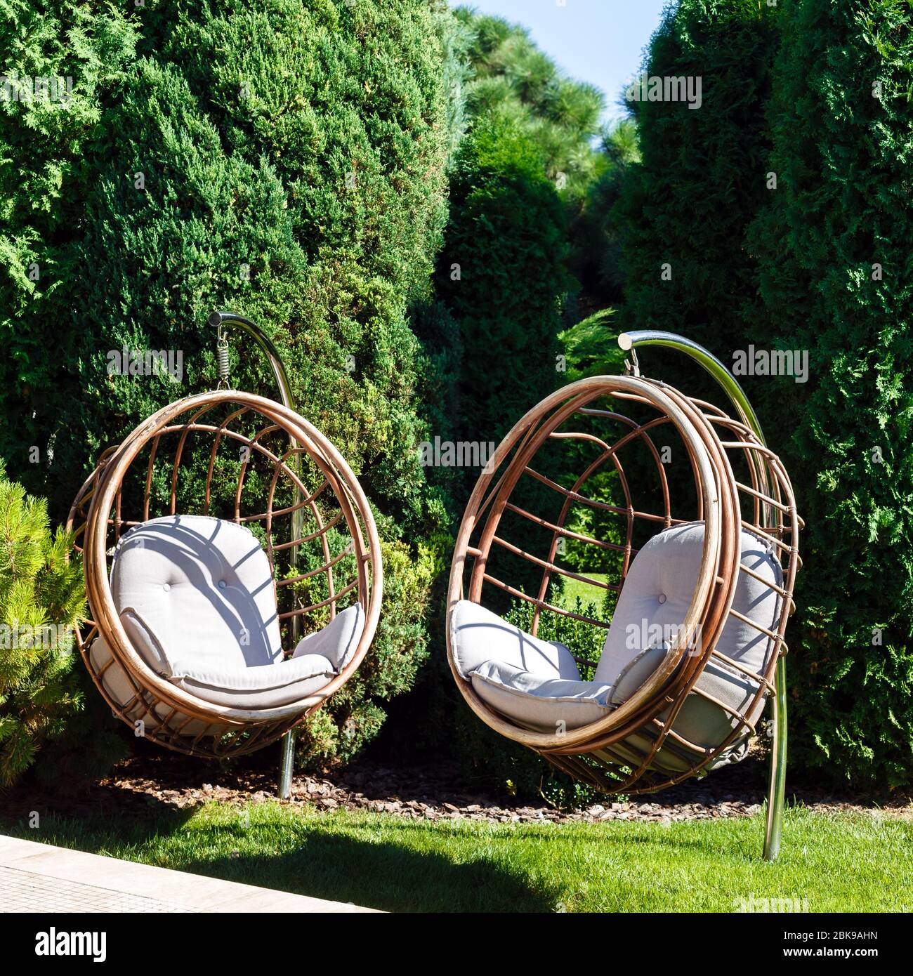 Dos sillas colgantes en el jardín en un soleado día de verano. Lugar para  recreación al aire libre Fotografía de stock - Alamy