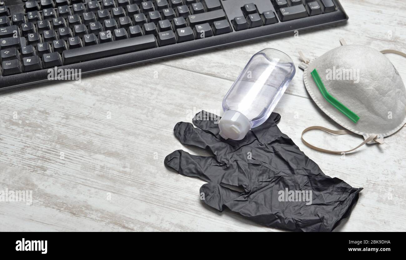 gel hidroalcohólico, máscara antipolvo y guantes en un escritorio con  teclado Fotografía de stock - Alamy