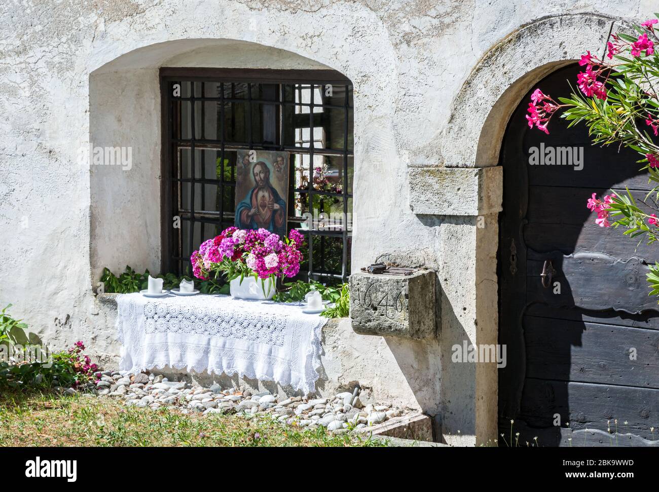 Ventana decorada con jarrón de flores para las fiestas de Corpus Christi en el sur del Tirol, Trentino Alto Adige, Italia Foto de stock