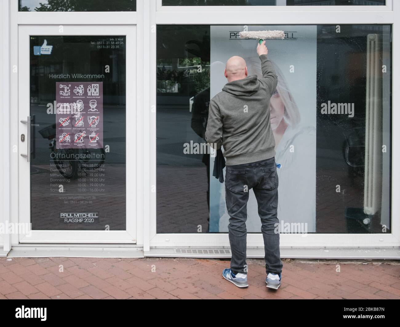 Hanover, Alemania. 3 de mayo de 2020. Matthias limpia la ventana de una  peluquería en el centro de la ciudad. A partir del lunes (04 de mayo), los  peluqueros podrán reabrir su