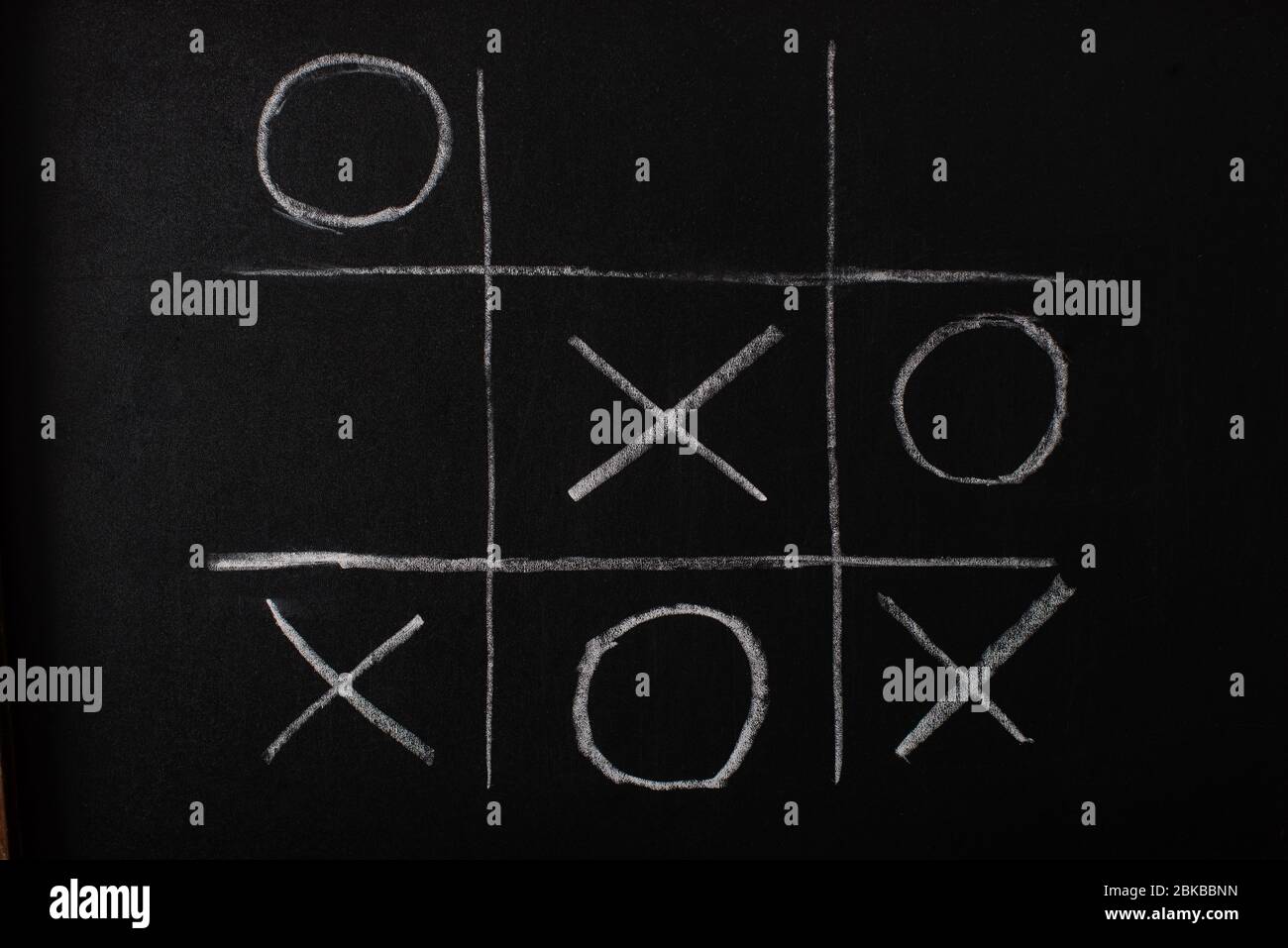 vista superior del juego tic tac toe sobre pizarra con cuadrícula de tiza,  traviesas y cruces Fotografía de stock - Alamy