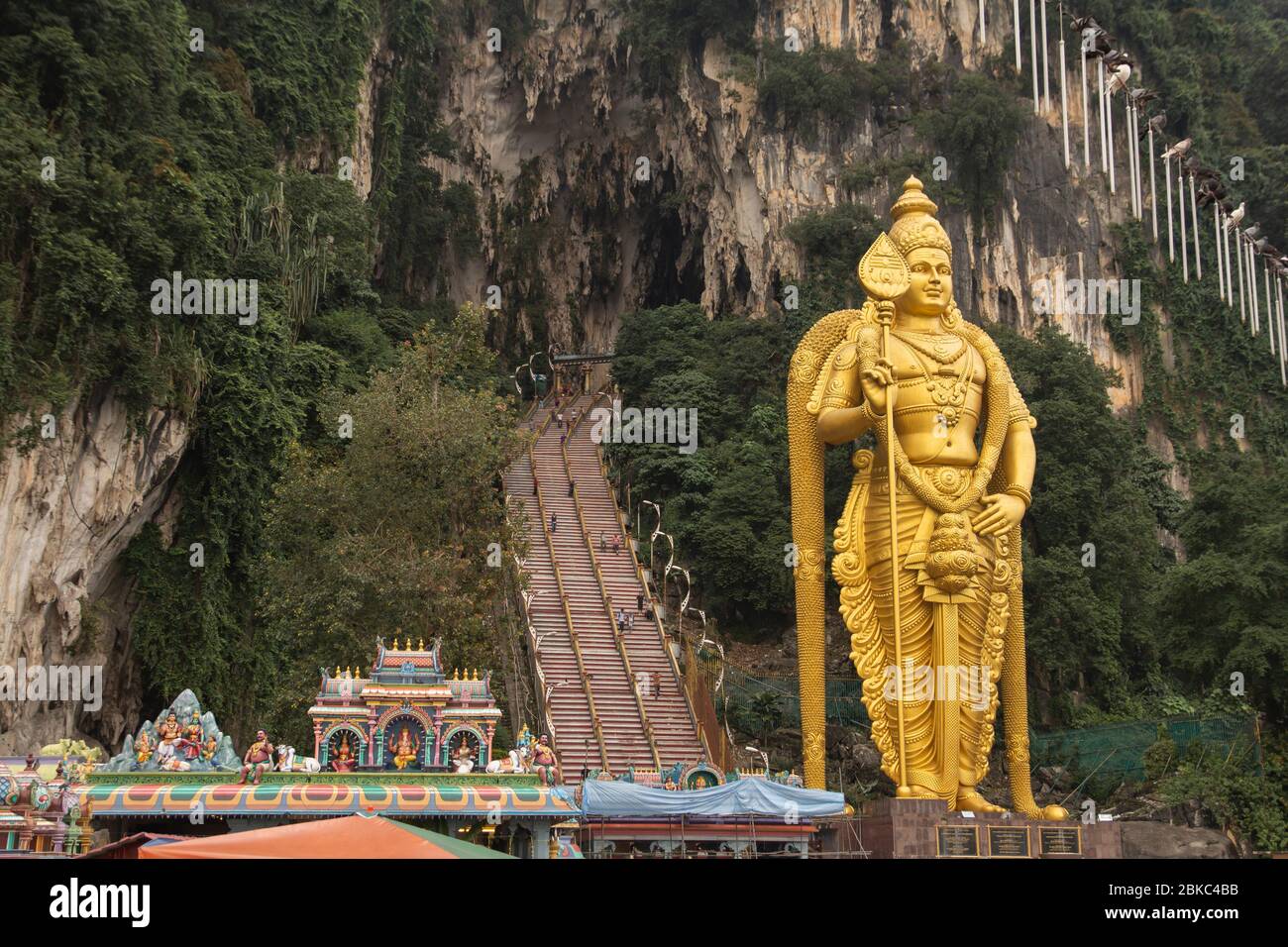Enorme estatua de oro hindú frente a las cuevas de Batu Foto de stock