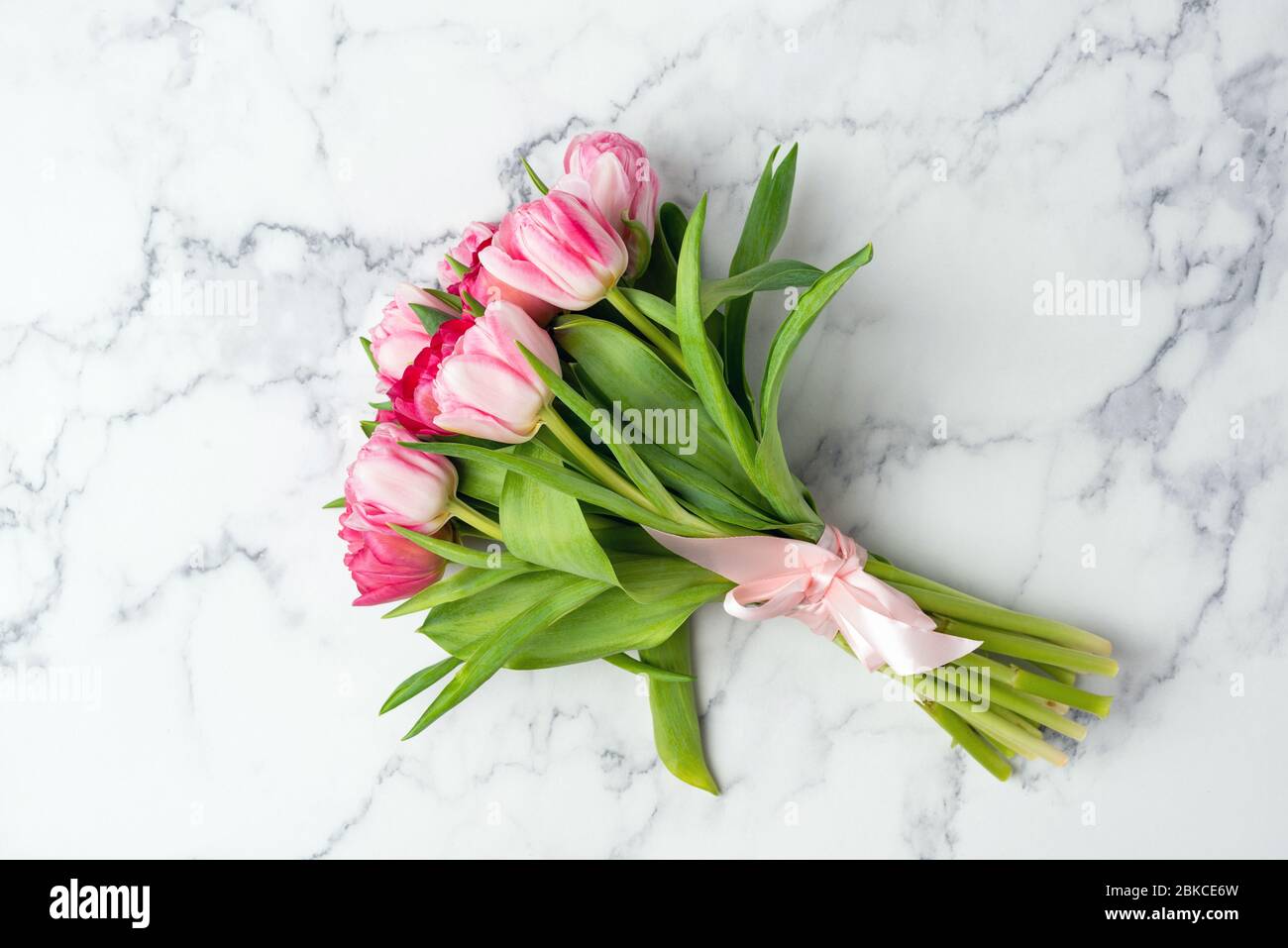 Ramo de tulipanes de peony sobre fondo de mármol. Vista superior. Día de la madre, día de la boda flores concepto Foto de stock