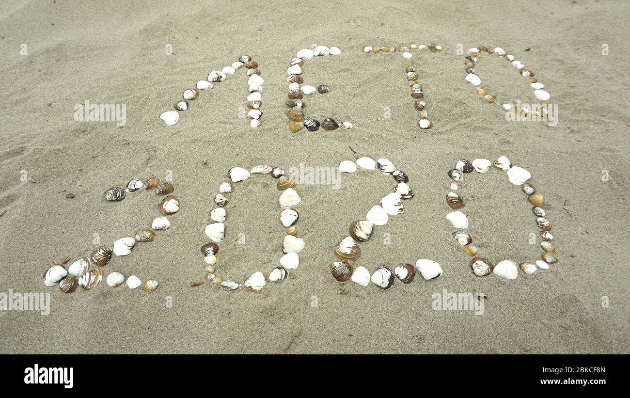 Verano de 2020, palabra rusa con conchas escritas en la playa, guión cirílico (Лето 2020 Foto de stock