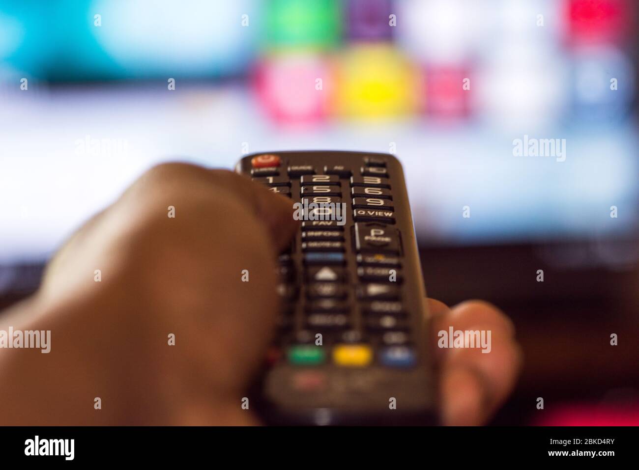 Persona que utiliza el mando a distancia de Smart TV Foto de stock