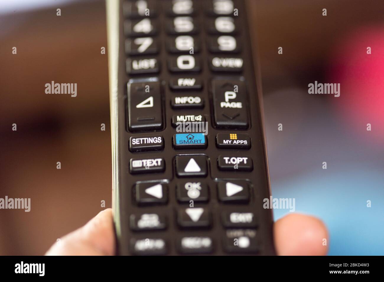 Persona que utiliza el mando a distancia de Smart TV Foto de stock