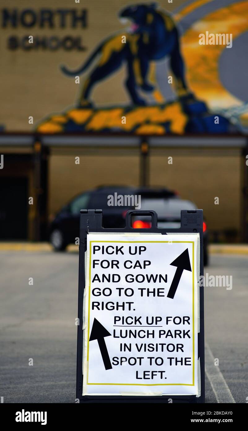 Carol Stream, Illinois, EE.UU. Un cartel en un estacionamiento proporciona dirección para aquellos que recogen gomas y batas para los graduados de la escuela secundaria. Foto de stock