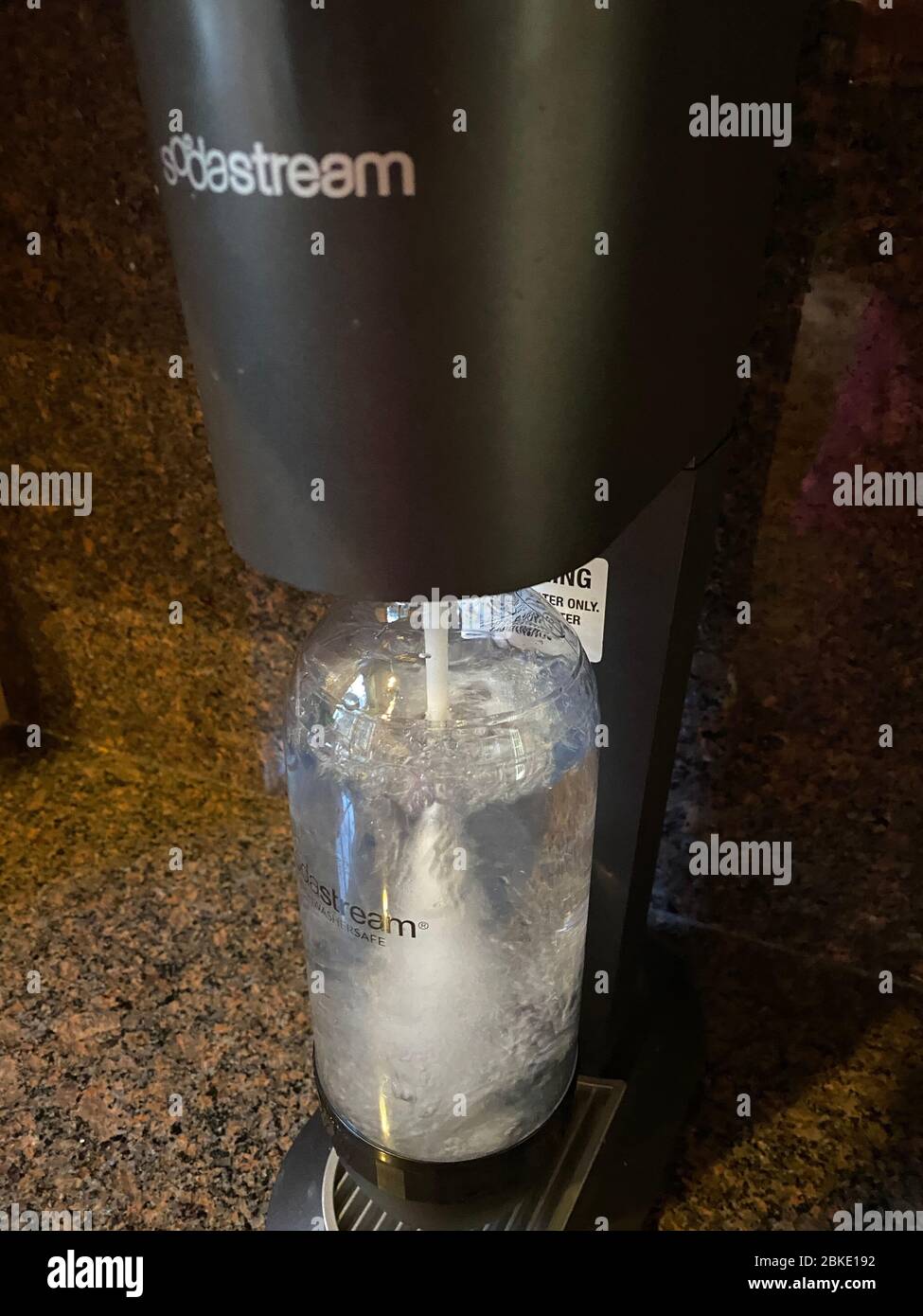 Hacer agua con gas con una máquina SodaStream que agrega carbonatación al  agua corriente. Los consumidores pueden utilizar esto para ayudar a  eliminar los plásticos de un solo uso Fotografía de stock 