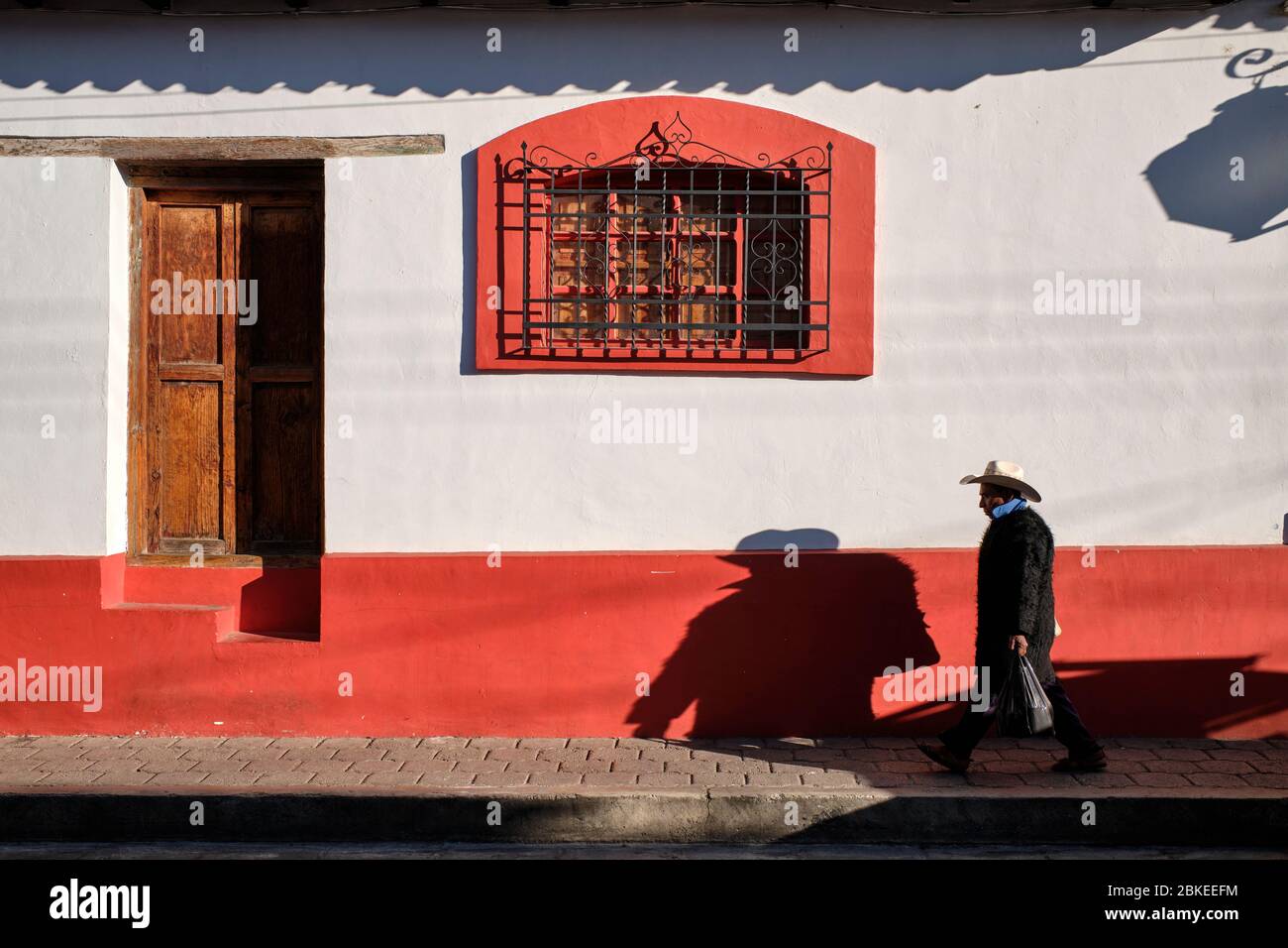 Hombre con ropa indígena típica caminando con bolsas por las coloridas