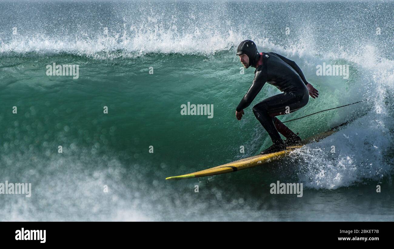 Una imagen panorámica de un surfista en Fistral en Newquay en Cornwall. Foto de stock