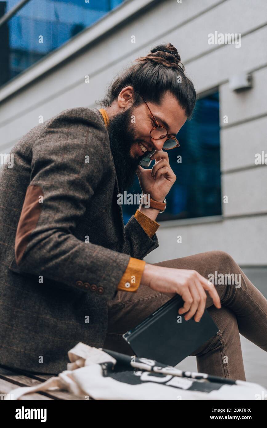Procesando Contratación Comité Hombre de moda con ropa moderna y con estilo hablando por teléfono en la  plaza de la ciudad Fotografía de stock - Alamy