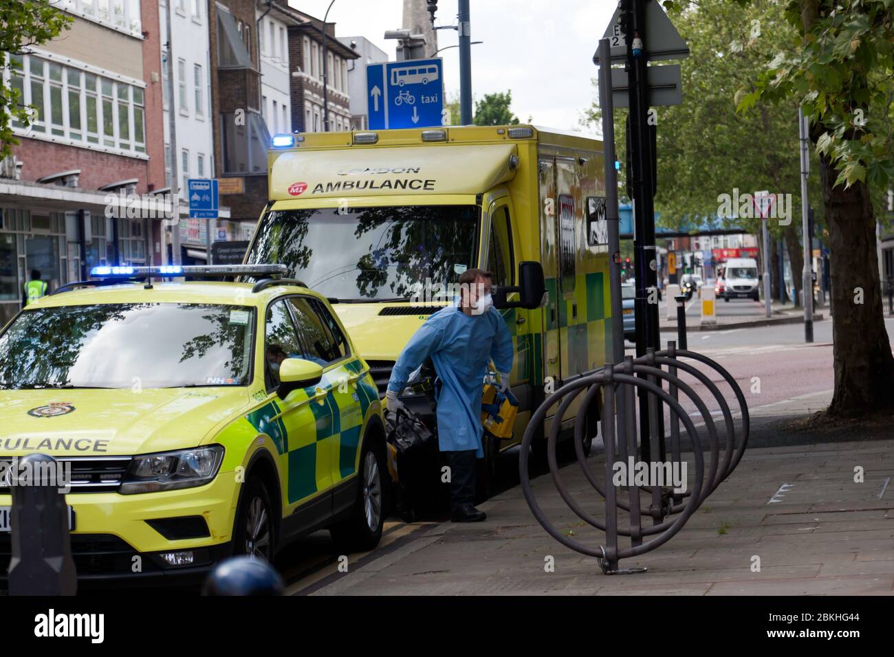 Londres ambulancia Crewmember, vestido con Equipo de Protección personal, llega a Lewisham Hight Street, para asistir a una emergencia médica, durante la pandemia de COVID-19 Foto de stock