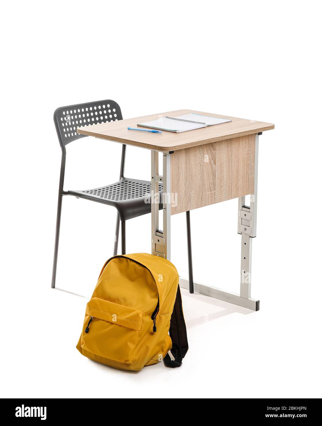 Escritorio de la escuela con silla y mochila sobre fondo blanco