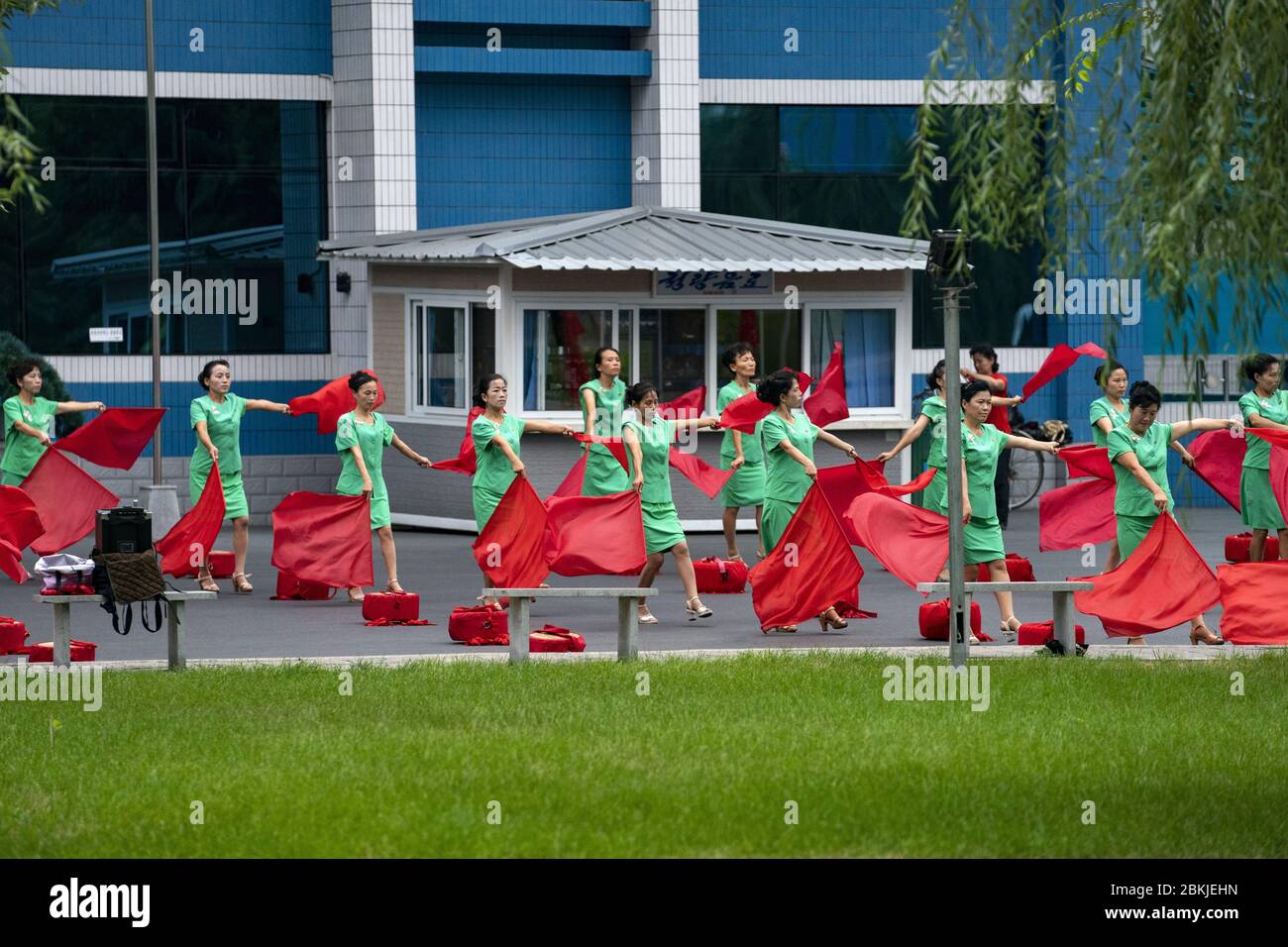 Corea del Norte, Pyongyang, mujeres sin empleo que animan a la gente que trabaja Foto de stock