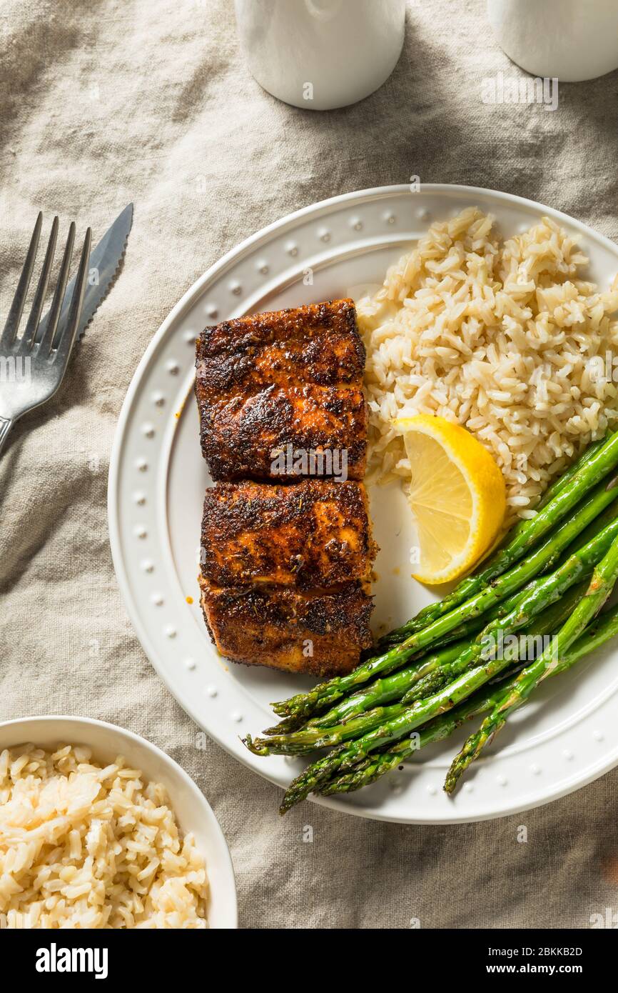 Pescado blanco Mahimahi ennegrecido casero con espárragos y arroz Foto de stock