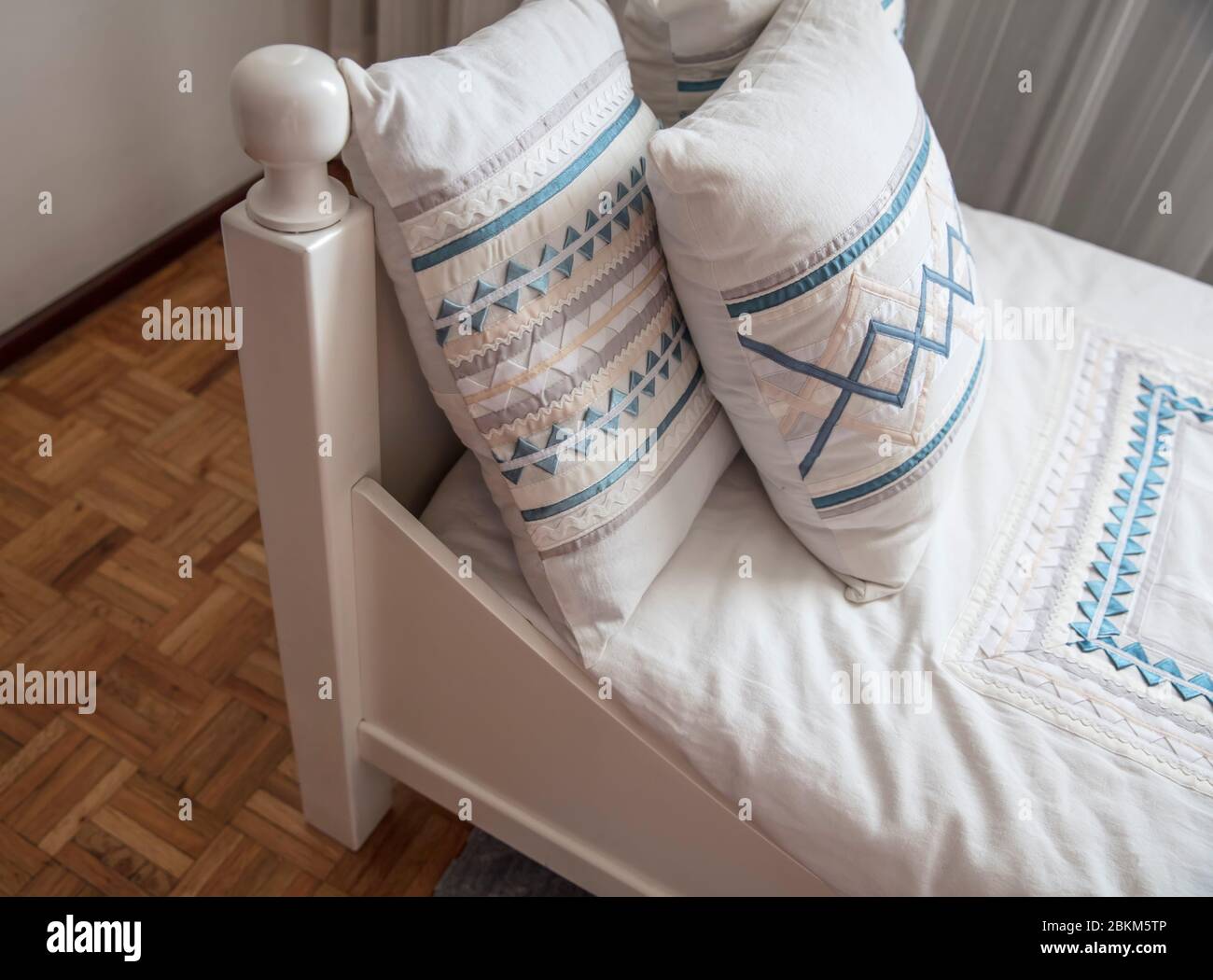 cama individual en esquina con almohadas con bordes Foto de stock