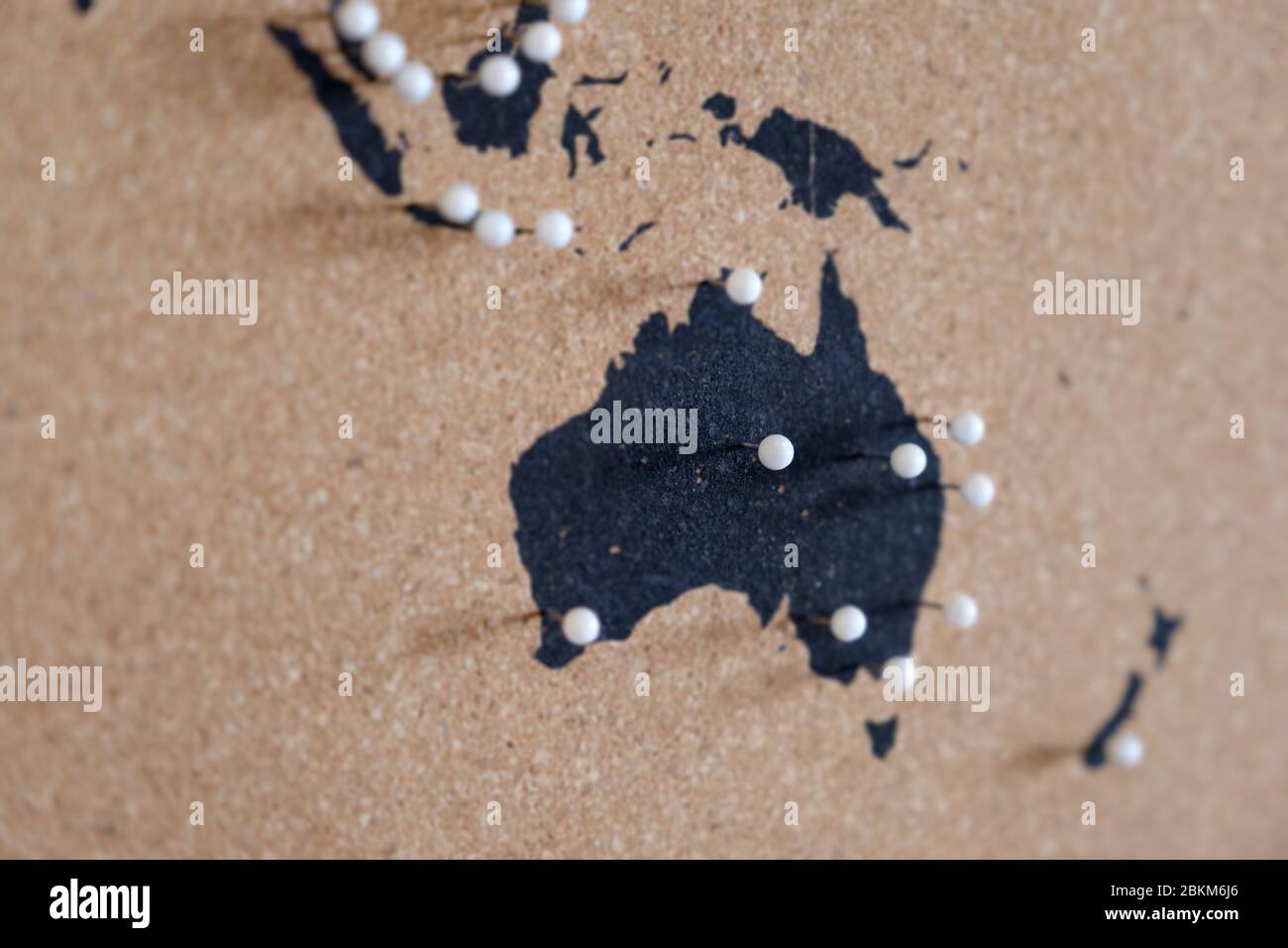 Mapa de Australia y Oceanía circundante en un tablón de corcho mostrando con orgullo la historia de los viajes con pins blancos. Foto de stock
