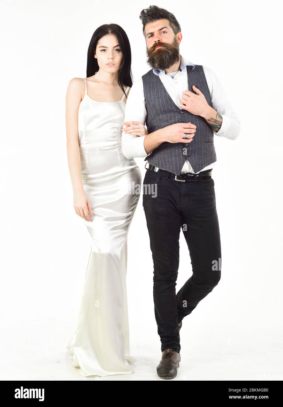 Pareja en amor, novia y novio en elegante ropa de boda, fondo blanco. Mujer en vestido de boda y hombre en chaleco. Concepto de boda. Cintura baja con barba con novia vestida Pareja en amor, novia y novio en elegante ropa de boda, fondo blanco. Mujer en vestido de boda y hombre en chaleco. Concepto de boda. Cintura baja con barba con novia vestida