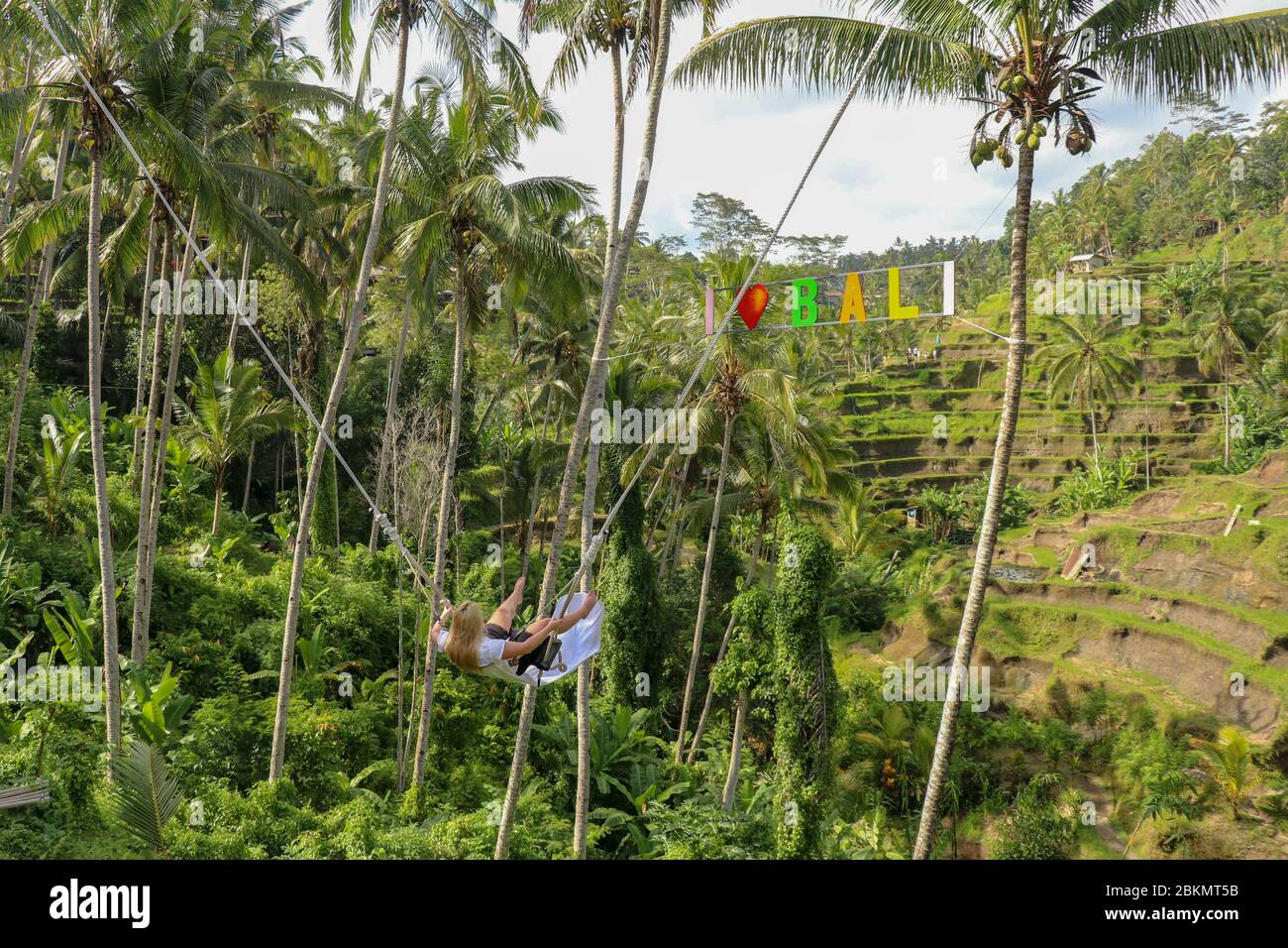 Una niña se asesta en un columpio sobre un cañón alto. Joven turista que se  balancea en un acantilado en la selva tropical de Tegalalang, Bali.  Oscilación Fotografía de stock - Alamy