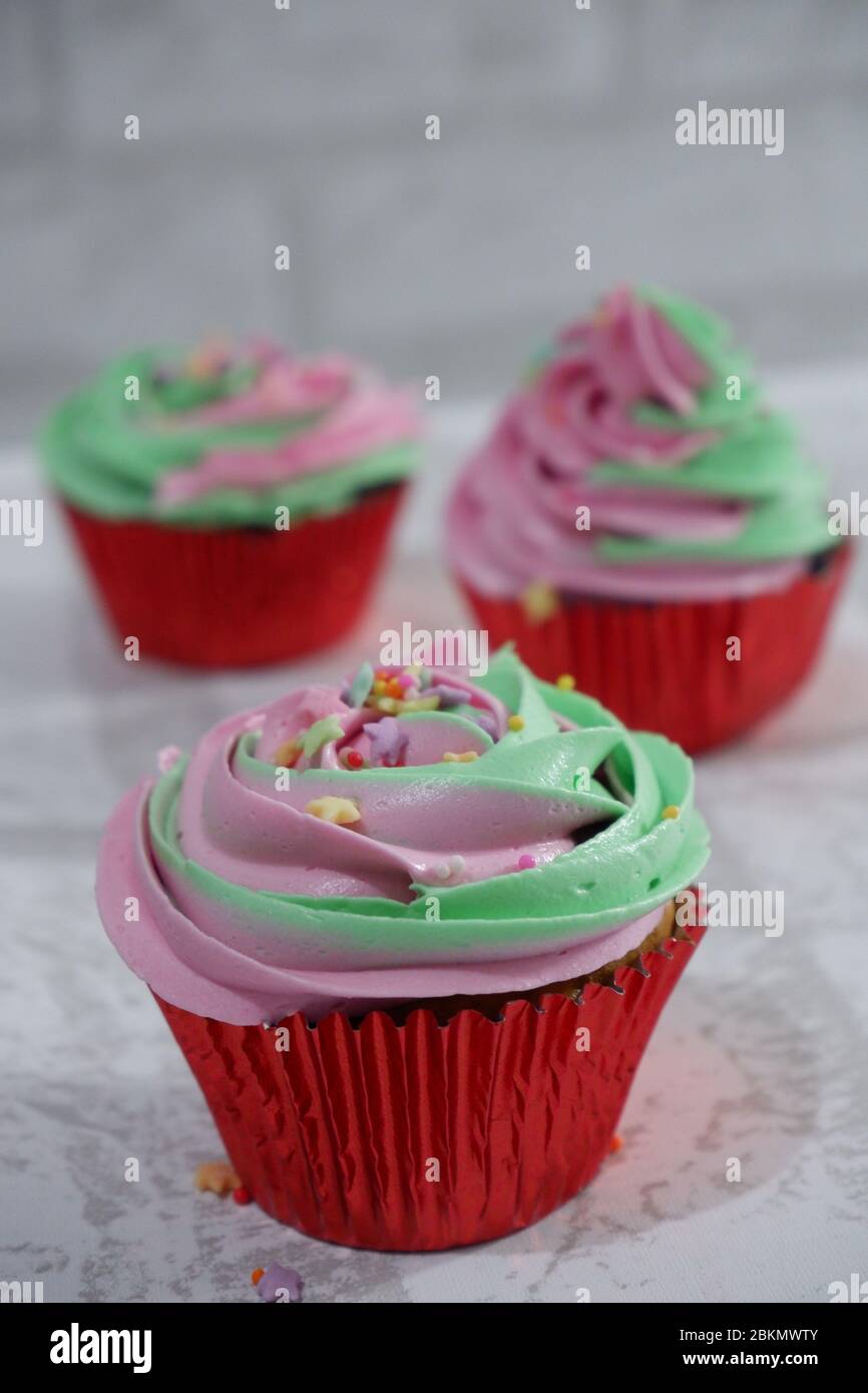 Grupo de cupcakes de dos colores, rosa y verde lima Foto de stock