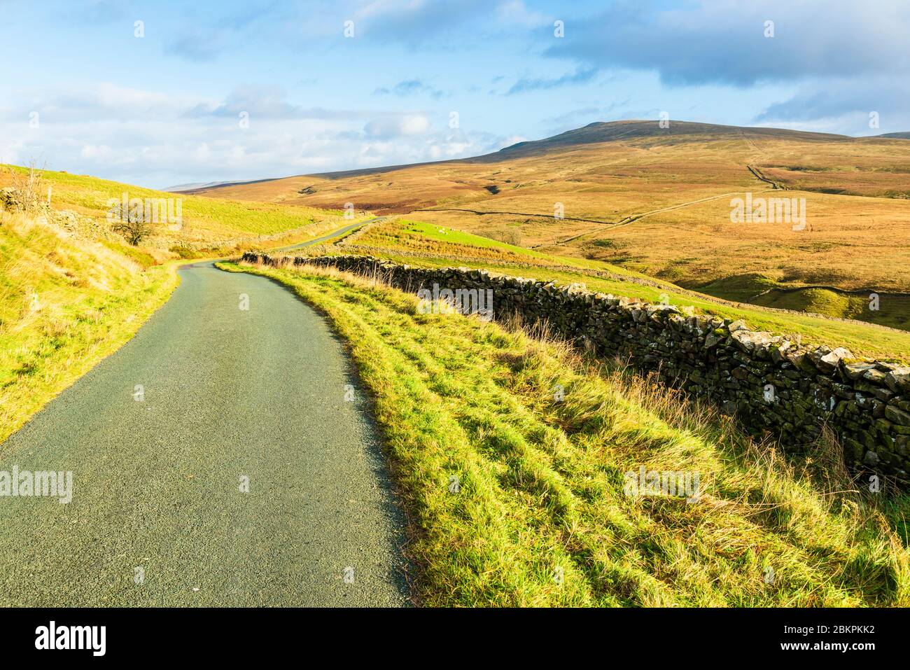 Carretera sobre el valle de Leck Beck y Ease Gill, en la frontera de Lancashire-Cumbria, con Great Coum y Crag Hill en el horizonte Foto de stock