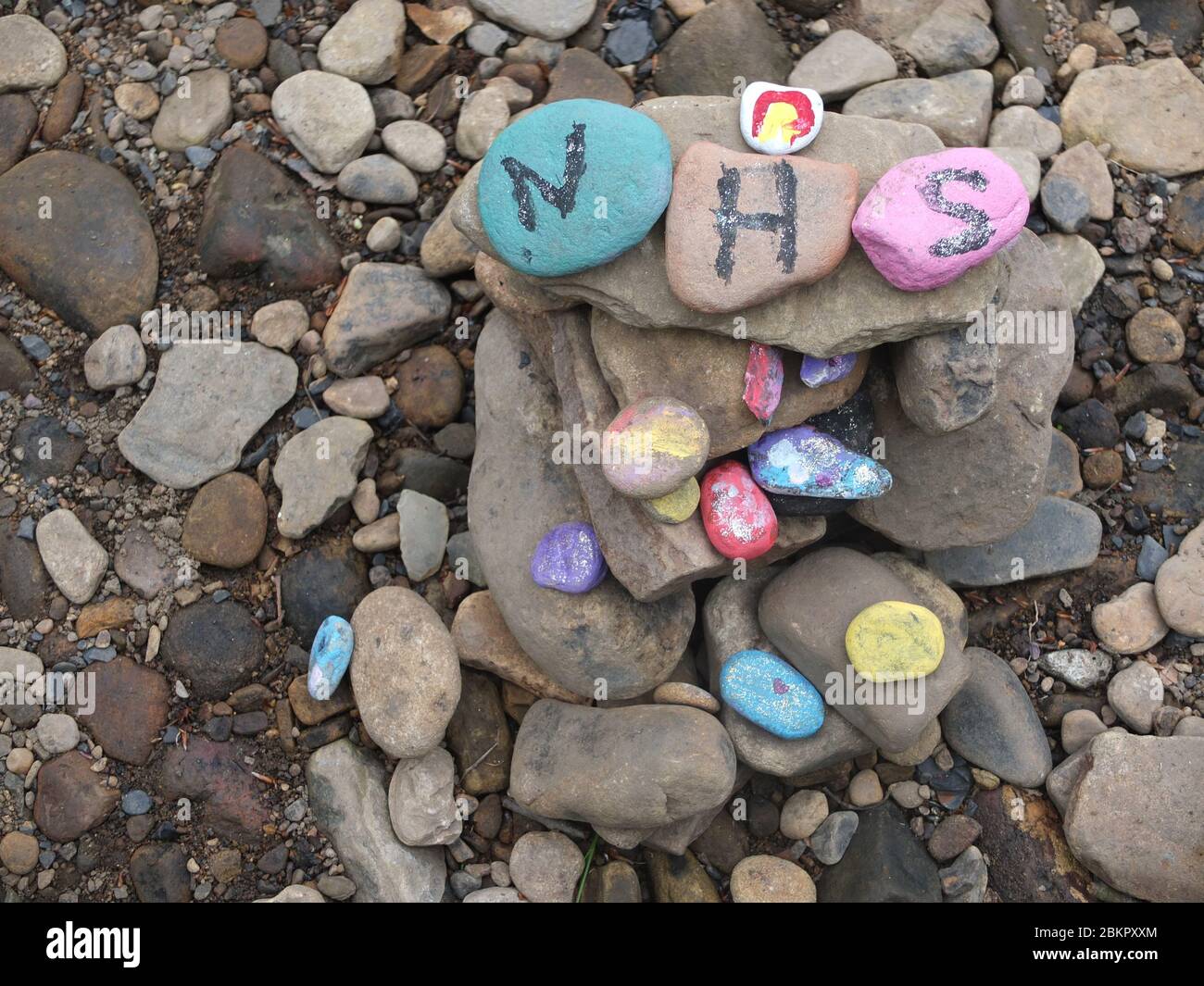 Piedras pintadas con mensajes de gratitud por NHS en el secreto 'jardín de hadas' por río en Sheffield, Reino Unido, que ha surgido durante el cierre del Coronavirus Foto de stock