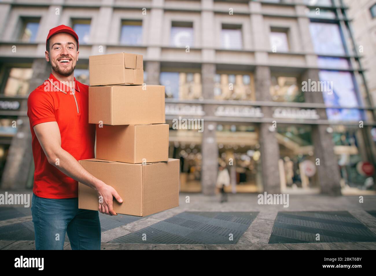 Red Courier en el exterior transporta paquetes para entregas de envíos  Fotografía de stock - Alamy