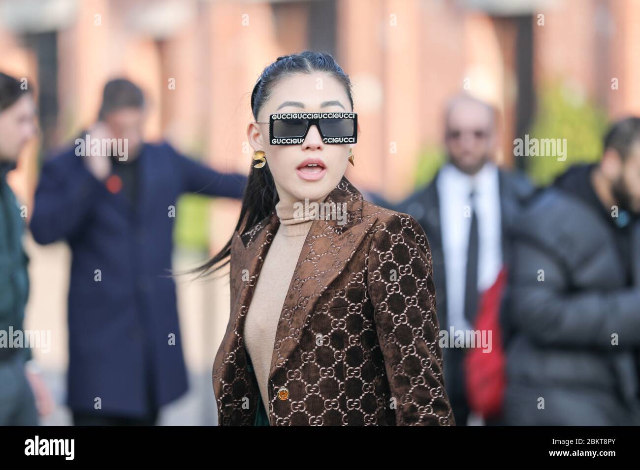 Febrero 19, 2020: Modelo asiático lleva un par de gafas Gucci y una  chaqueta de terciopelo marrón durante el desfile de moda Gucci en la semana  de la moda femenina otoño Fotografía