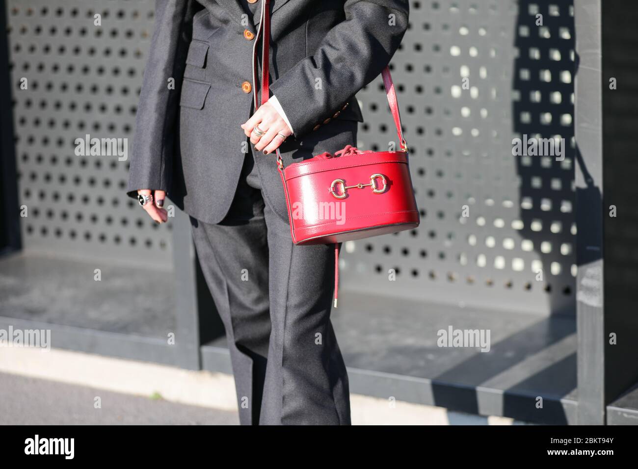 Febrero 19, 2020: Modelo lleva un traje negro y una bolsa de maletero roja  durante el desfile de moda Gucci en la semana de moda femenina otoño /  invierno 2020 en Milán