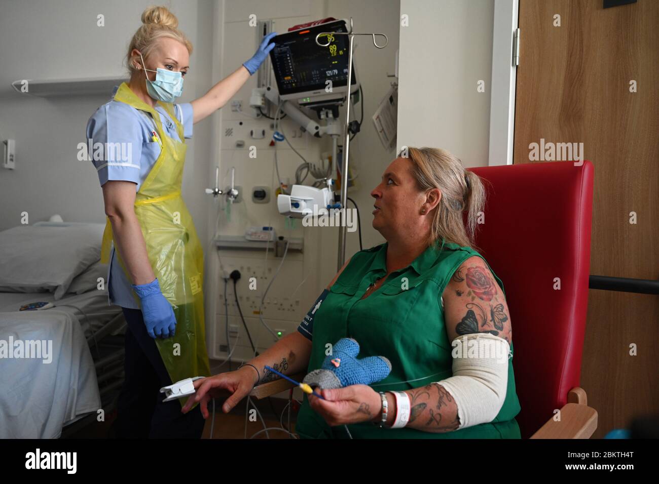 Un miembro del personal clínico lleva el equipo de protección personal (PPE) mientras ella cuida para el paciente Trudy Woodfall que se está recuperando del coronavirus en el barrio de recuperación de Covid en el hospital real de Papworth en Cambridge. Foto de stock