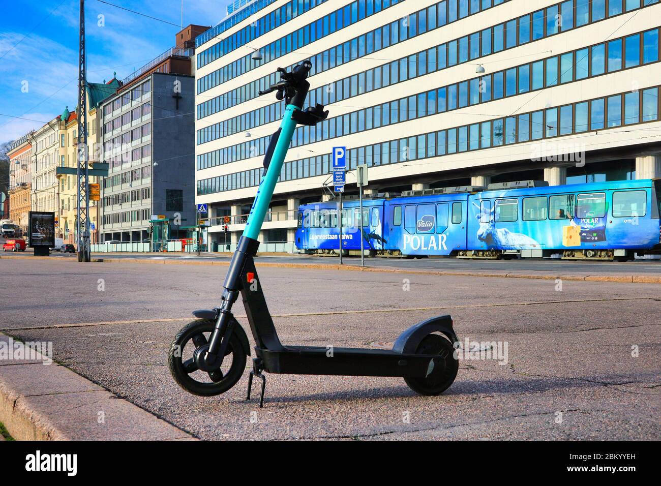 Scooter eléctrico de nivel o e-scooter estacionado en la zona peatonal de la ciudad, tranvía en el fondo. Helsinki, Finlandia. 5 de mayo de 2020. Foto de stock