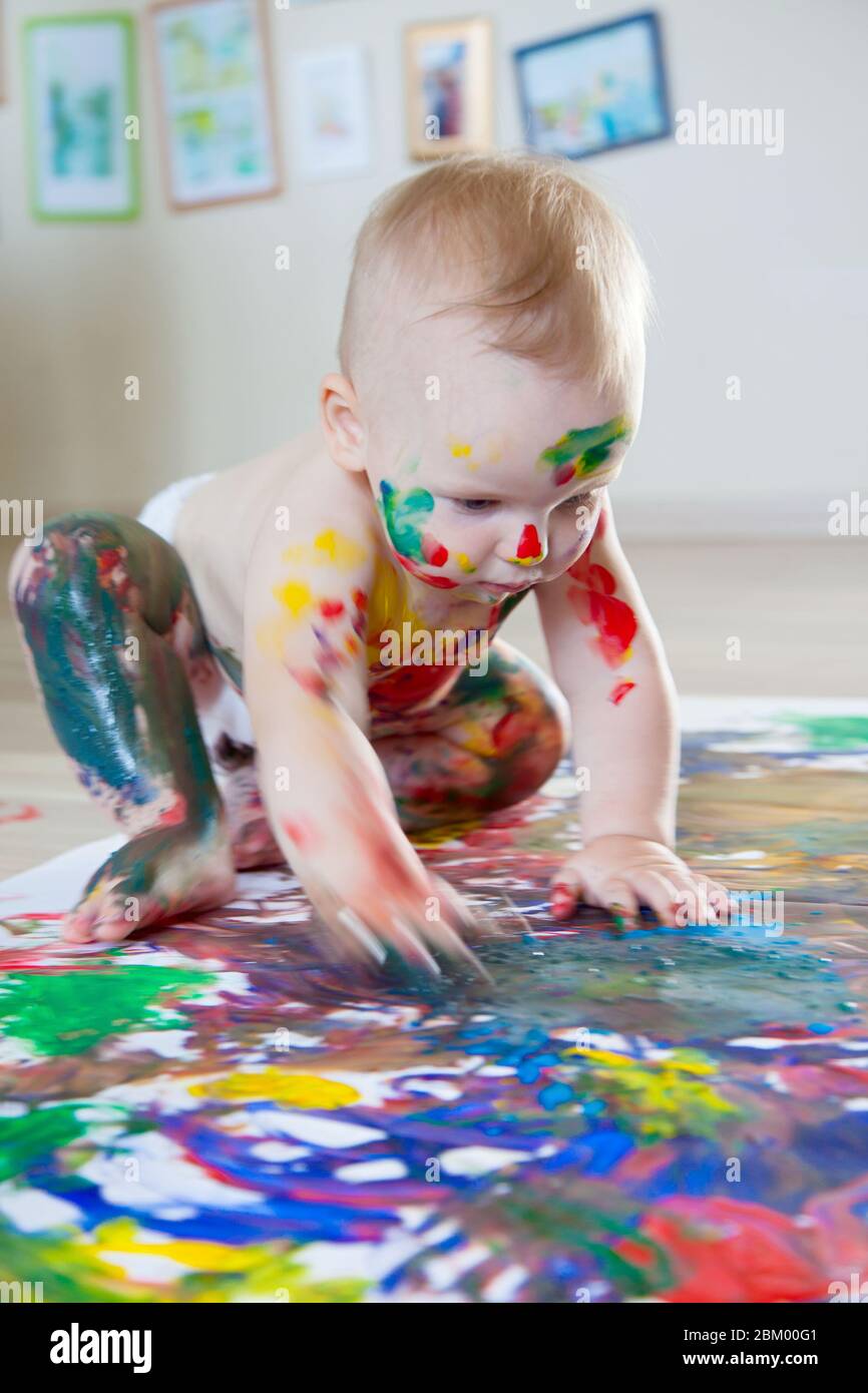Perjudicial dedo índice Profesión El bebé dibuja con las manos pintadas de colores, los pies y los dedos  sucios. Lista blanca Fotografía de stock - Alamy