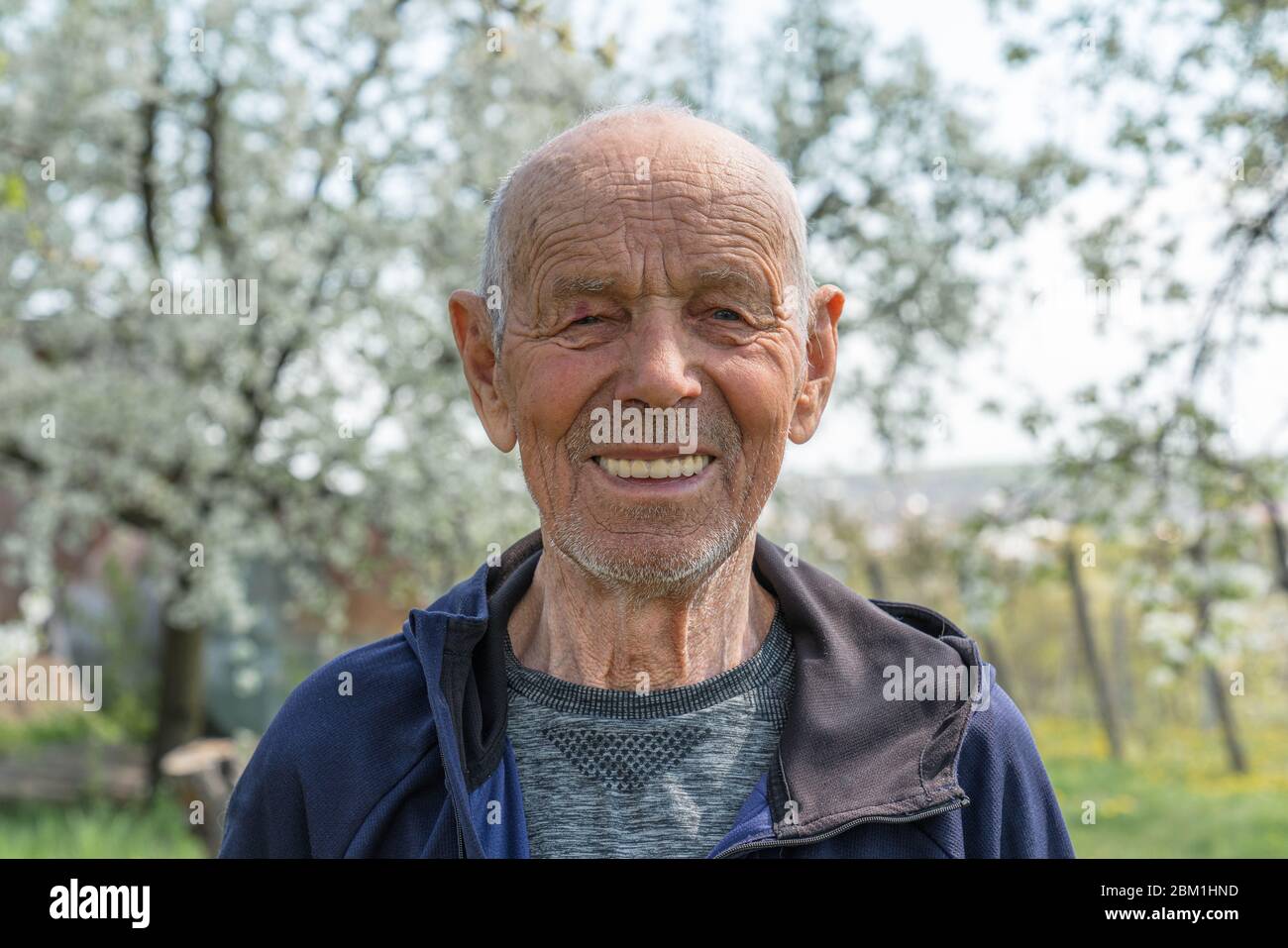 Primer plano retrato de un anciano feliz pensionista en ropa deportiva que  sonríe y mira la cámara Fotografía de stock - Alamy