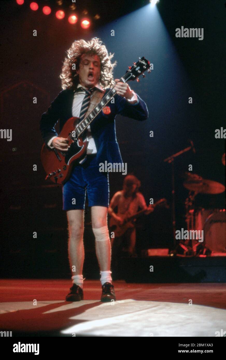DETROIT - 17 DE NOVIEMBRE: Angus Young, guitarrista principal de AC/DC, con  su icónico uniforme de colegialas británicas y tocando su Gibson SG rojo,  actúa durante la gira de la Flick of