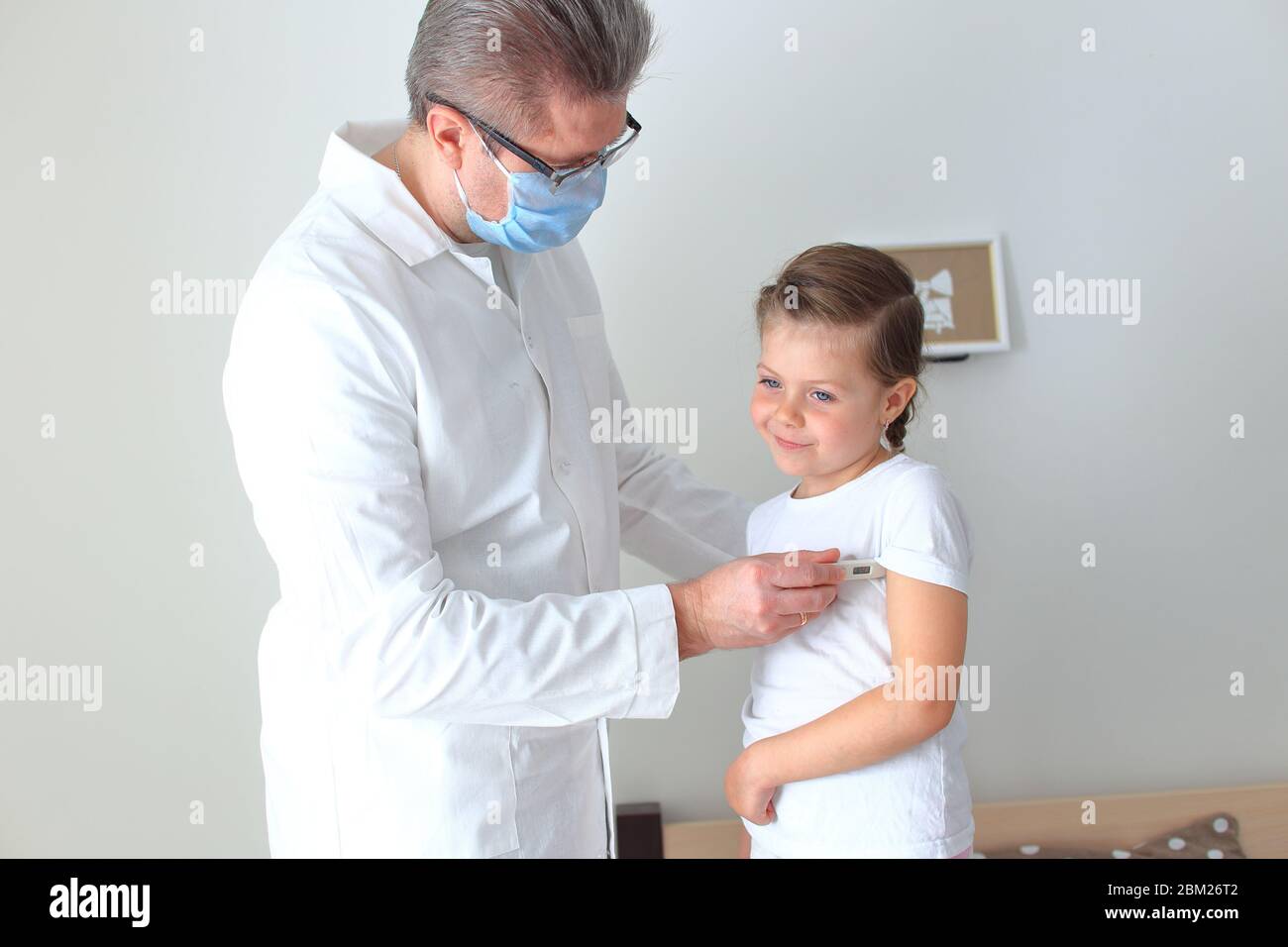 Médico examinando a una niña en casa Foto de stock