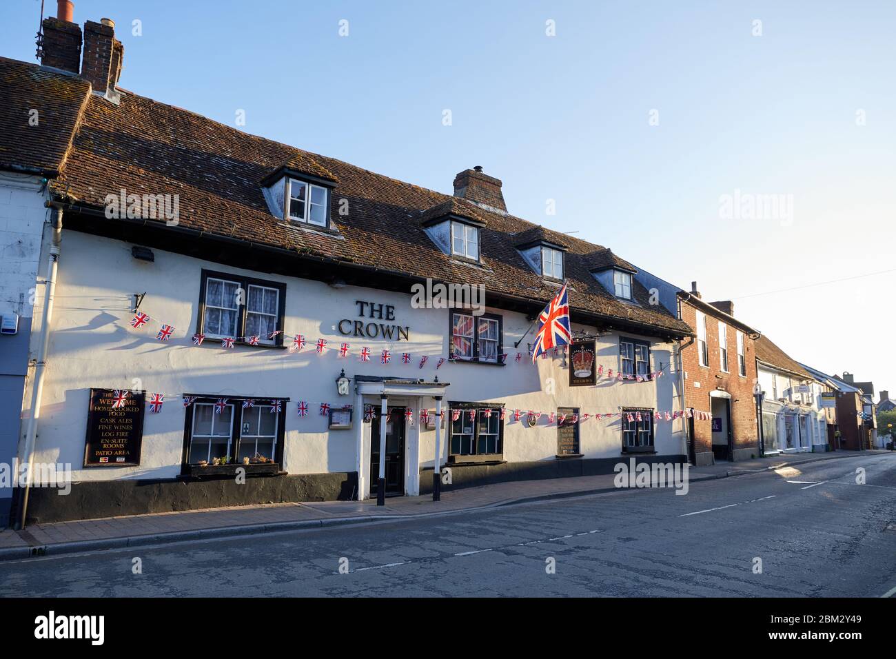 Fordingbridge, Reino Unido. - 6 de mayo de 2020: A pesar de estar cerrado durante el cierre del coronavirus el pub Crown en Fordingbridge, Hampshire está decorado en bunting para el día ve 75. Foto de stock