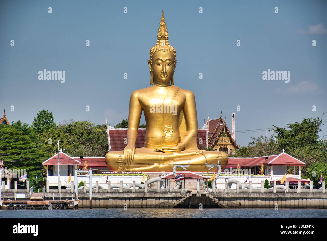 Un Buda dorado gigante en la actitud de Maravijaya es una actitud de Buda en el arte tailandés de la cual el Buda sentado está poniendo su mano en la postura de relajación Foto de stock