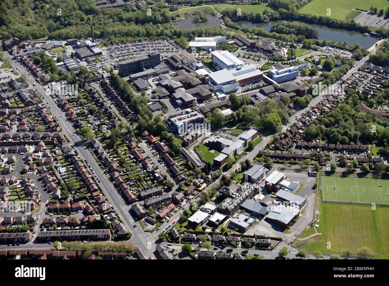 Vista aérea de Ashton Sixth Form College (primer plano) y Tameside General Hospital Foto de stock
