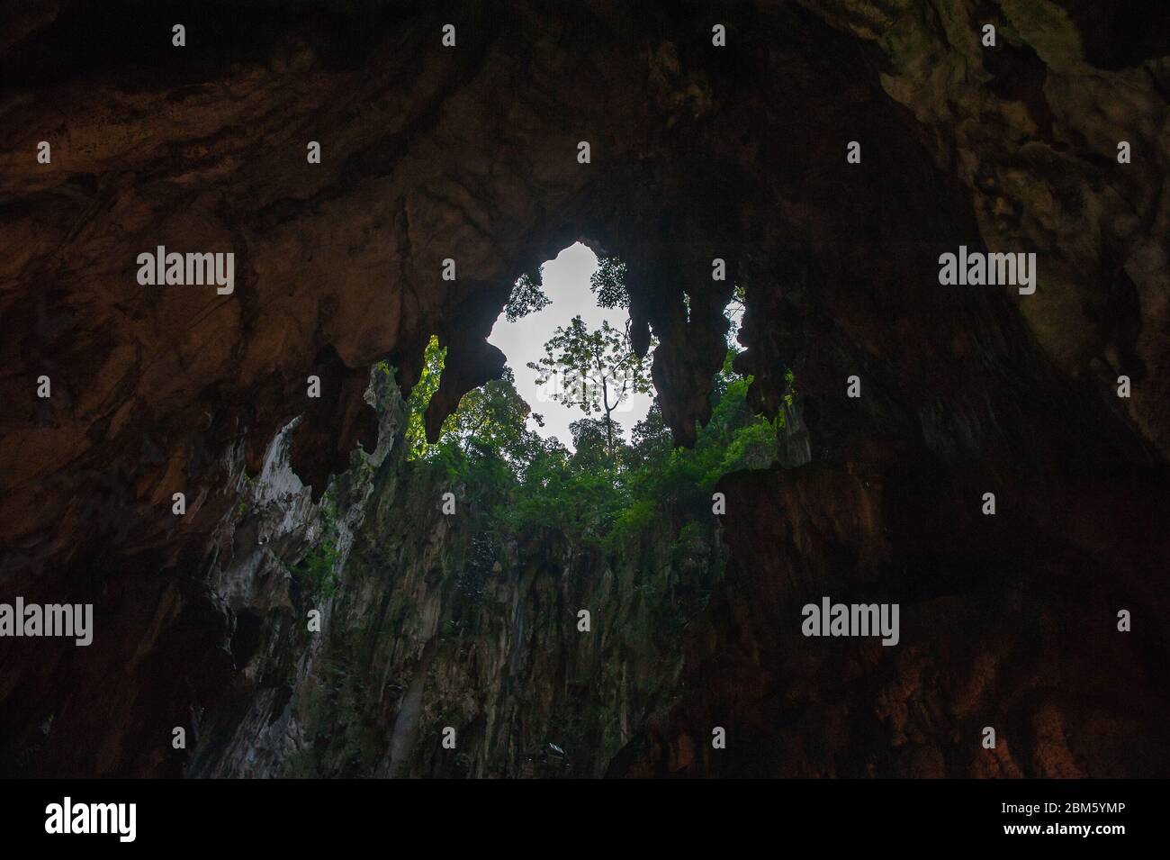 Las Cuevas de Batu, Selangor, Malasia. Vista a la claraboya natural y acantilados de piedra caliza desde el interior del edificio del templo Foto de stock