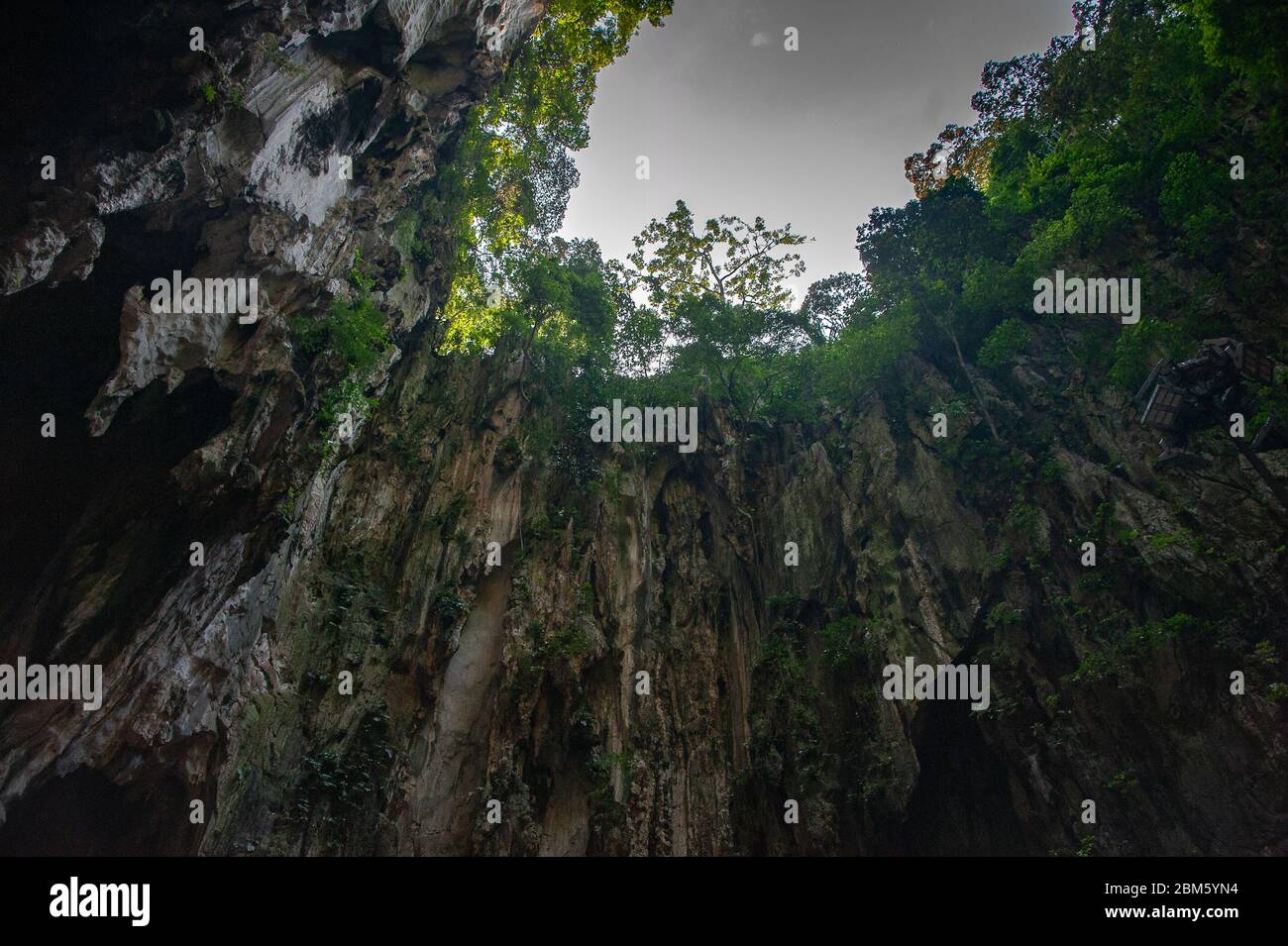 Las Cuevas de Batu, Selangor, Malasia. Vista a la claraboya natural y acantilados de piedra caliza desde el interior del edificio del templo Foto de stock