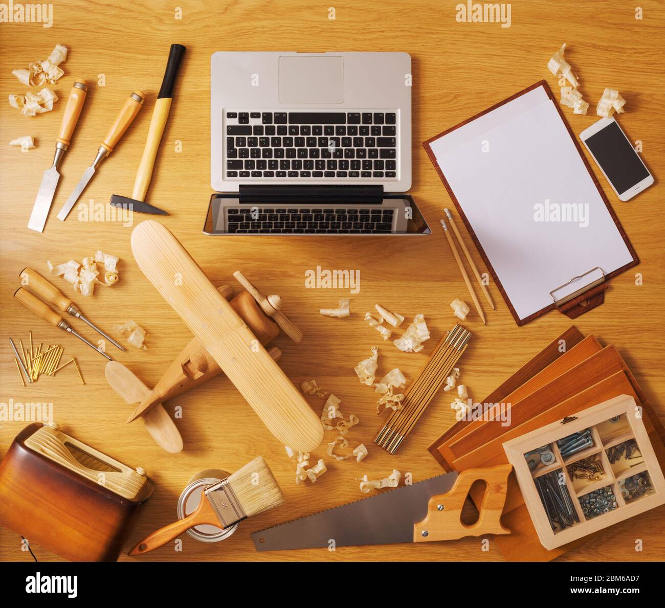 Proyecto de bricolaje en casa concepto, mesa de trabajo con avión de juguete de madera artesanales y herramientas de trabajo de carpintería, vista superior Foto de stock