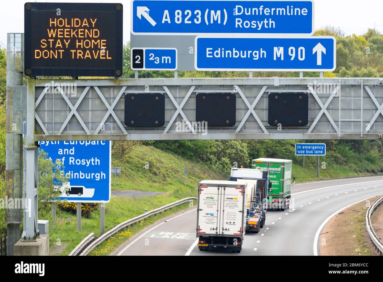 Dunfermline, Escocia, Reino Unido. 7 de mayo de 2020. El tráfico de la tarde en la M90 en Fife es notablemente más pesado de lo normal durante el bloqueo del coronavirus. Señal de advertencia que indica a los conductores que se quedan en casa durante el fin de semana de vacaciones. Iain Masterton/ Alamy Live News. Foto de stock