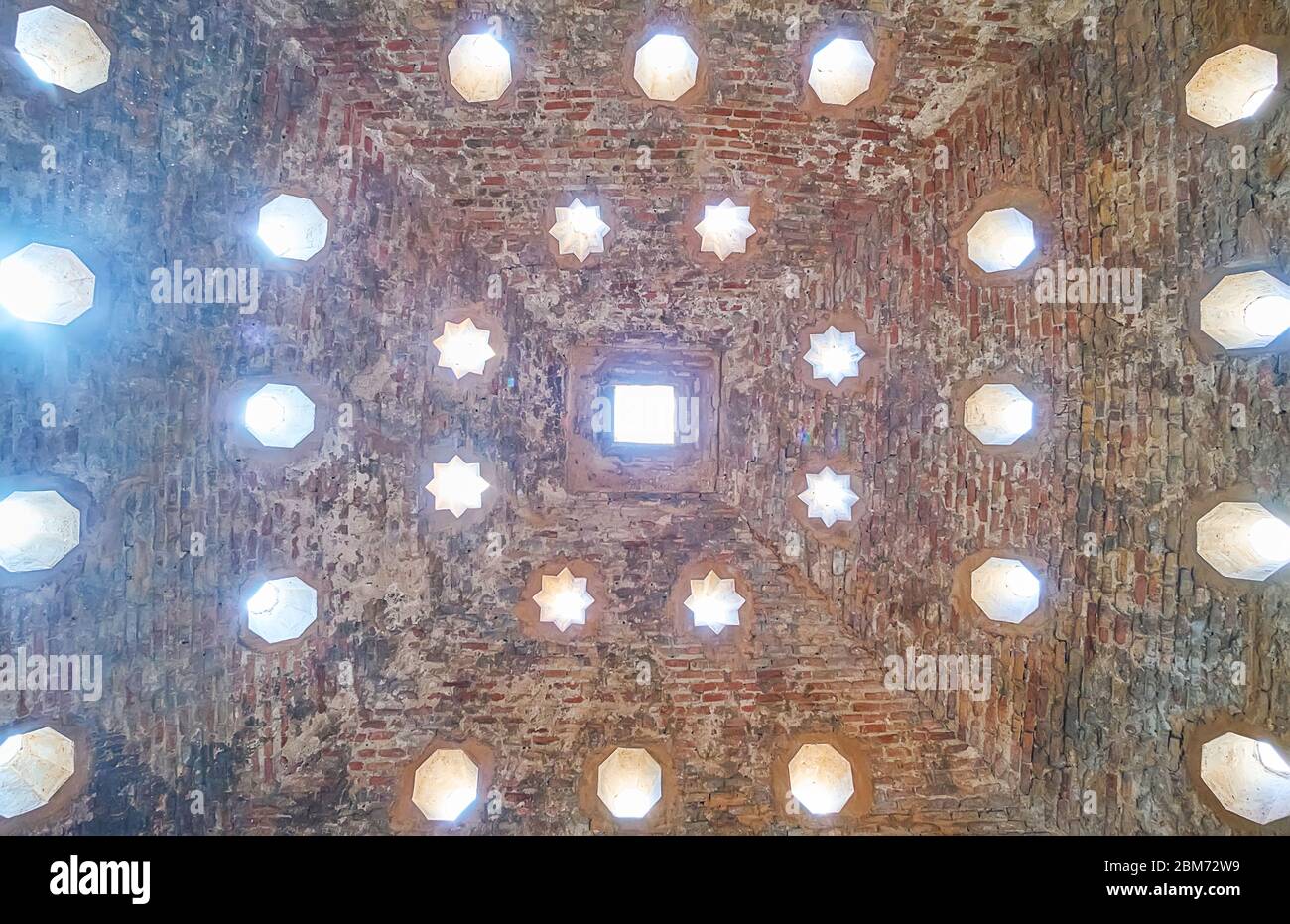 GRANADA, ESPAÑA - 25 DE SEPTIEMBRE de 2019: El techo de la cálida sala de el Banuelo (baños árabes, hammam) está decorado con agujeros claros en la bóveda, en forma de sta Foto de stock