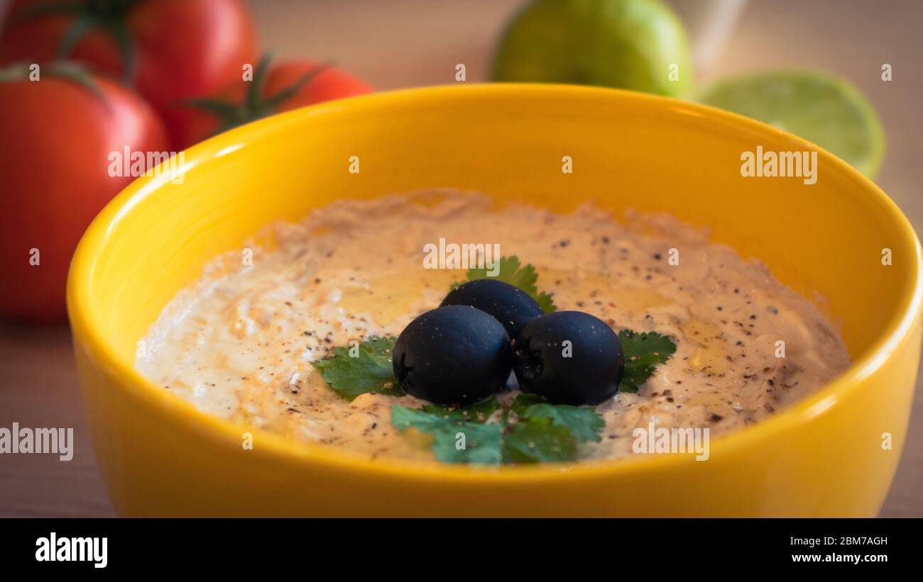 un cuenco con salsa de atún y algunos ingredientes alrededor en la mesa Foto de stock