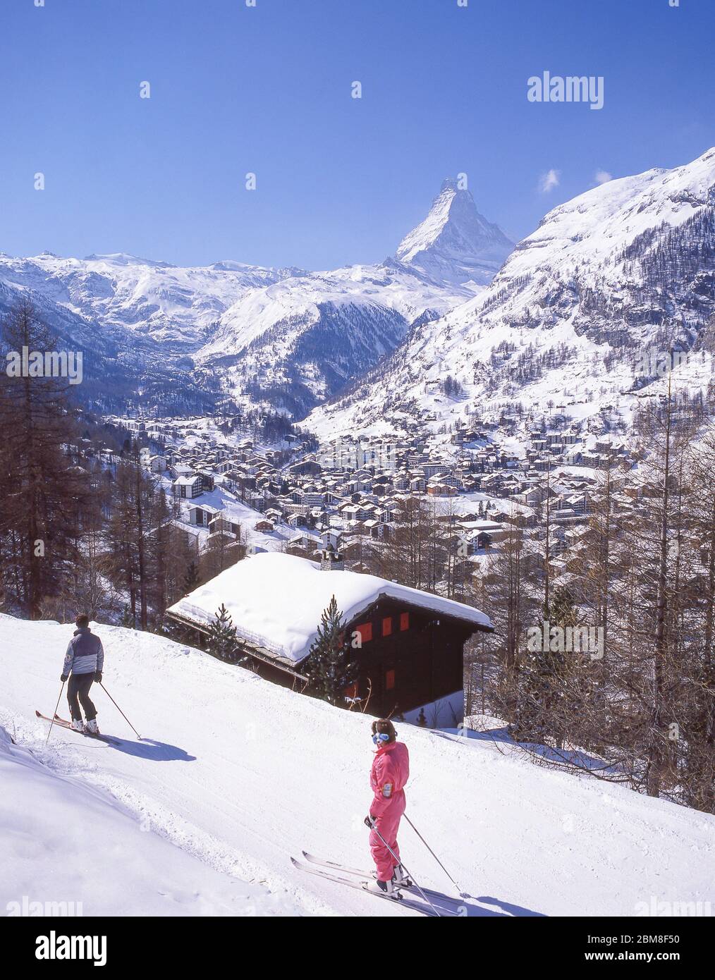 Esquiadores en pista de regreso al complejo turístico con la montaña Matterhorn detrás, Zermatt, el Valais, Suiza Foto de stock
