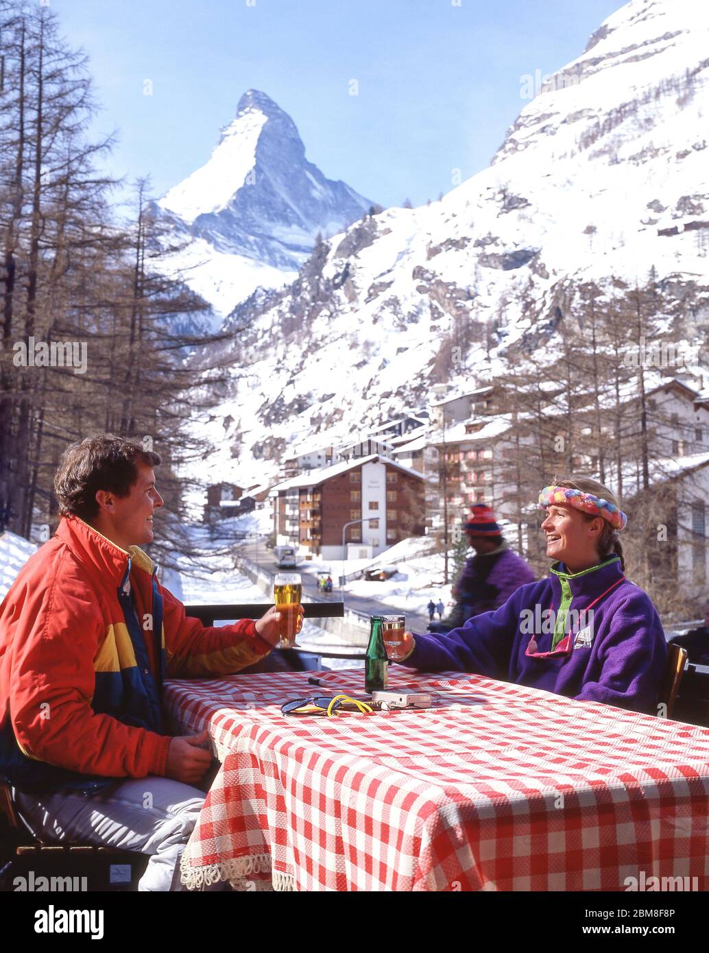 Pareja en el bar del complejo con la montaña Matterhorn detrás, Zermatt, el Valais, Suiza Foto de stock